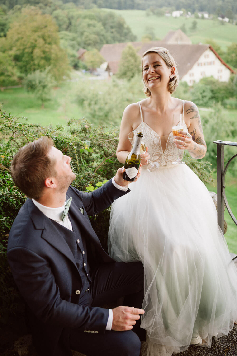 Groom toasting with bride as they celebrate with champagne, candid luxury wedding photography.