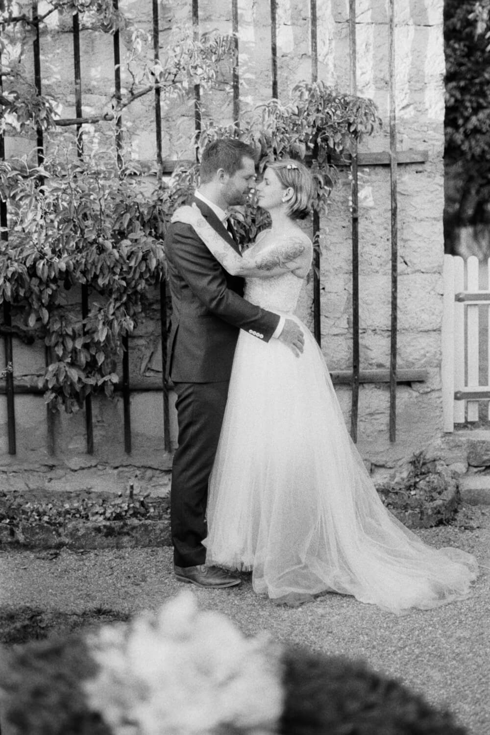 Bride and groom embracing in a romantic black and white wedding portrait, luxury wedding photography.