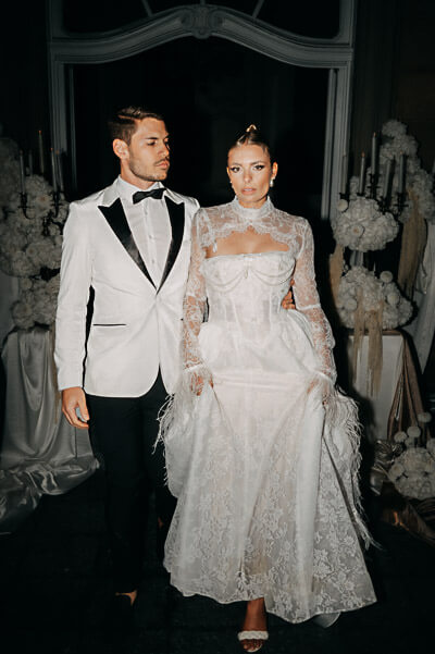 Swiss luxury wedding — fashion-forward night portrait with on-camera flash, white tux and lace dress; digital.