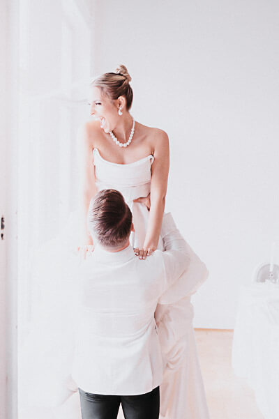luxury wedding — joyful window lift with the bride smiling in soft daylight; digital.