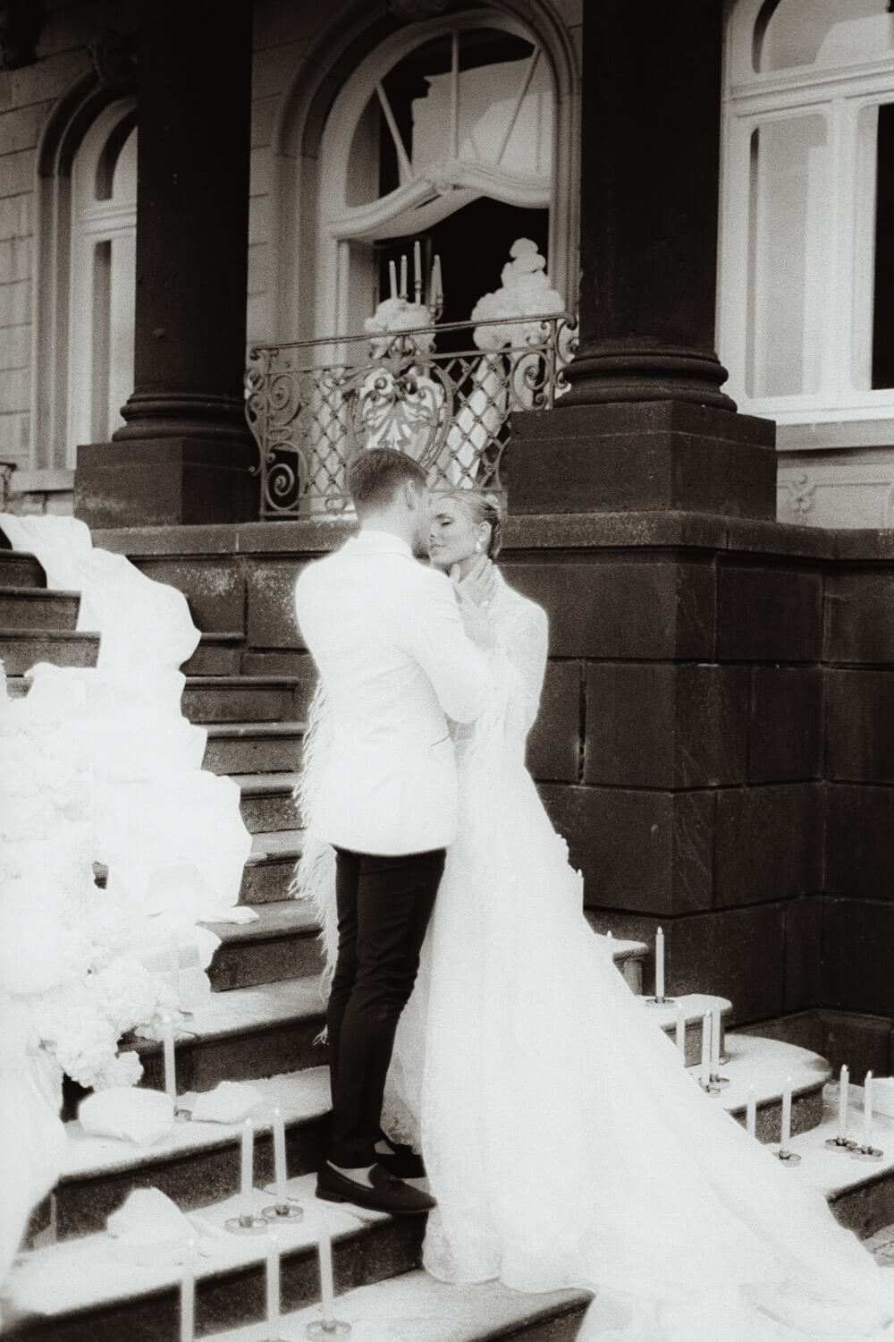 Black and white film photograph of a couple framed by classical architecture