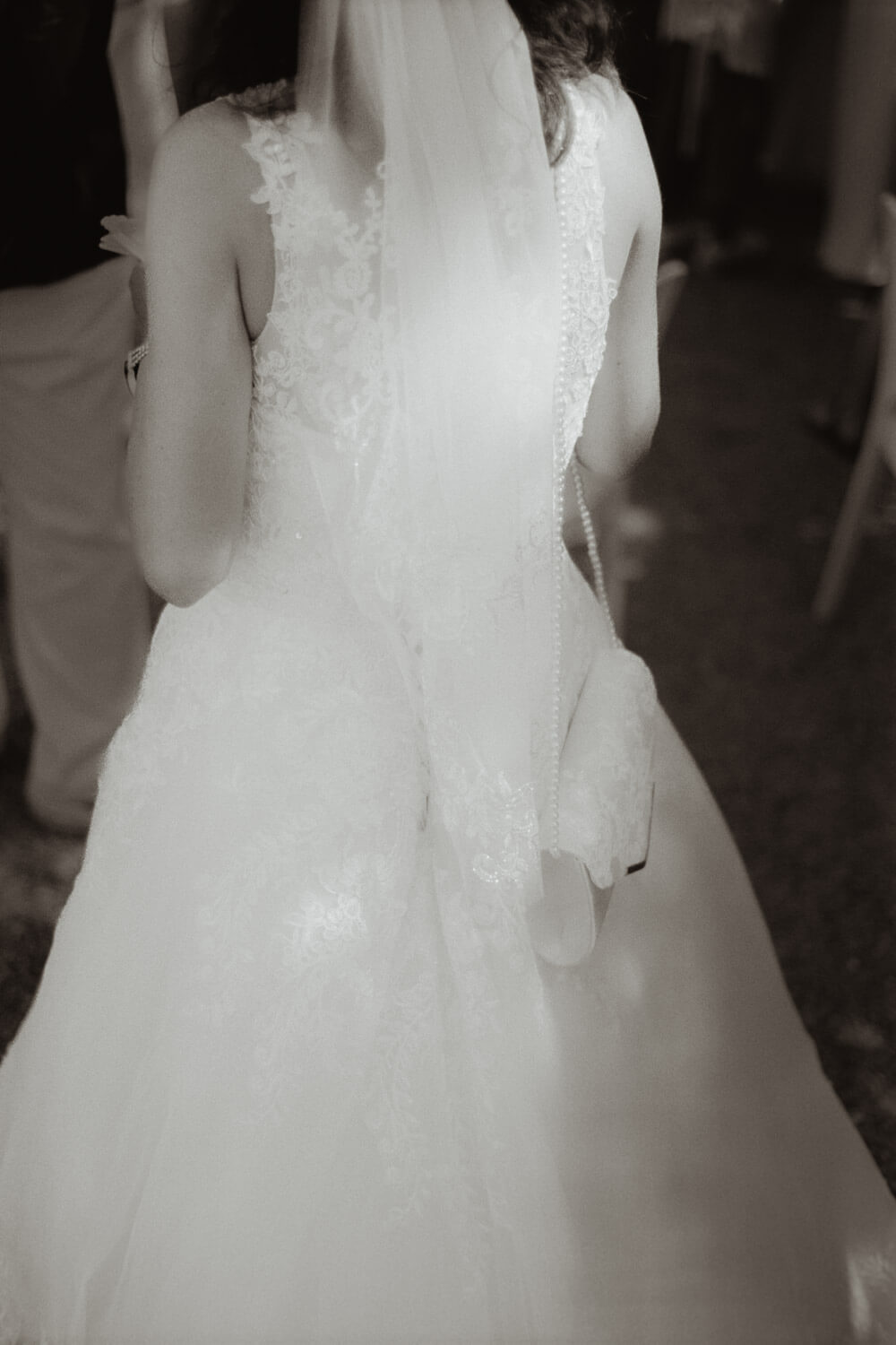 Black and white film detail of a wedding dress from behind