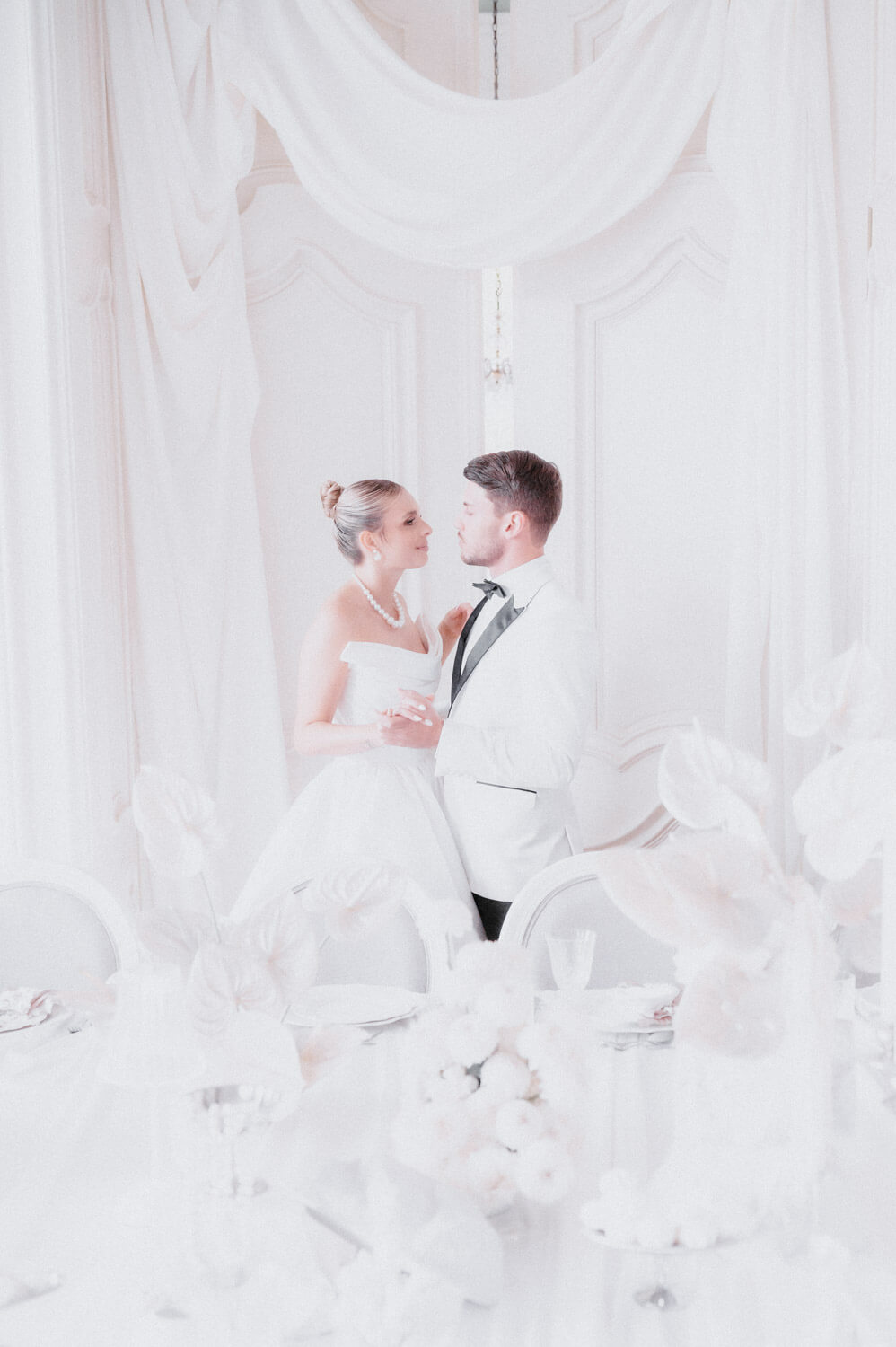 Wedding couple standing in soft daylight inside an elegant interior