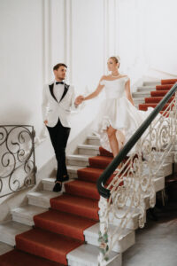 Bride and groom descending a grand staircase during an editorial wedding in Switzerland