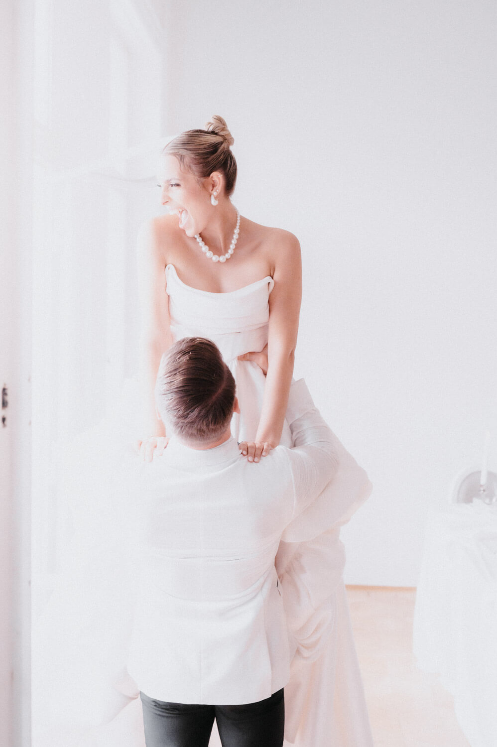 Emotional wedding moment as the groom lifts the bride during the celebration