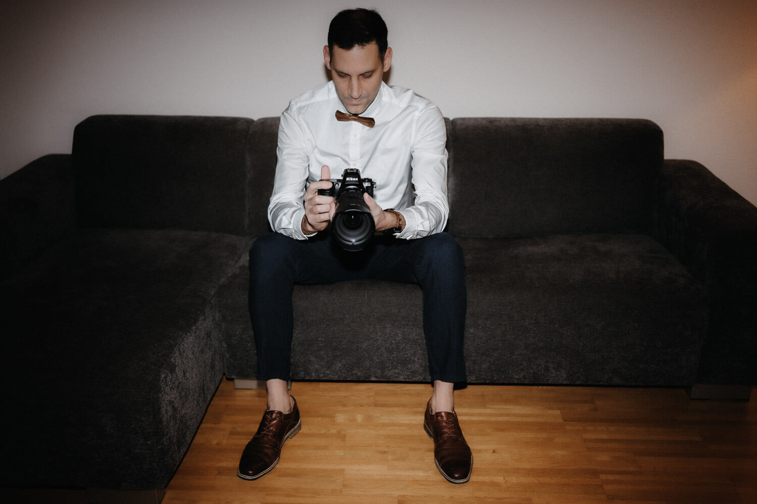 Wedding photographer David Rickenbach sitting calmly with camera in hand, focused and reflective.